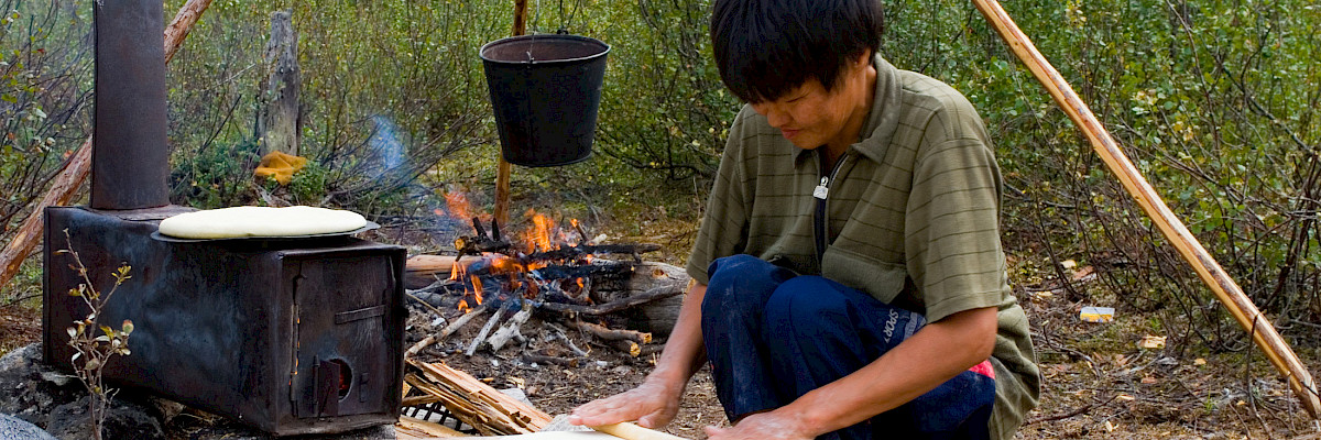 Evenki reindeer herder is making traditional Evenki bread – tupa. Neryungri District, Republic of Sakha (Yakutia), Russia. Credit: Yuri Kokovin