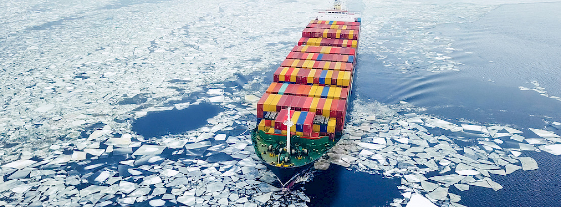Aerial view of a container ship in icy waters.