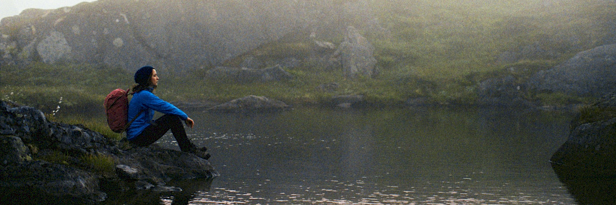 Woman sitting at a lake in Northern Norway